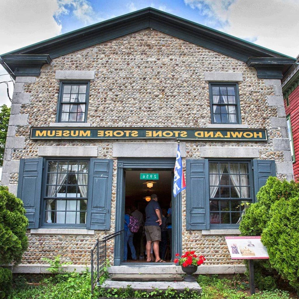 cobblestone building with blue trim with a sign over the door that says Howland Stone Store Museum